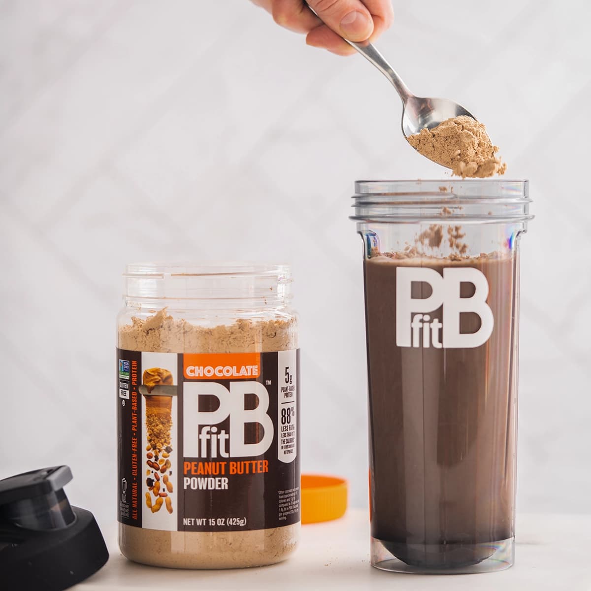 PBfit Cocoa being scopped into a blender bottle