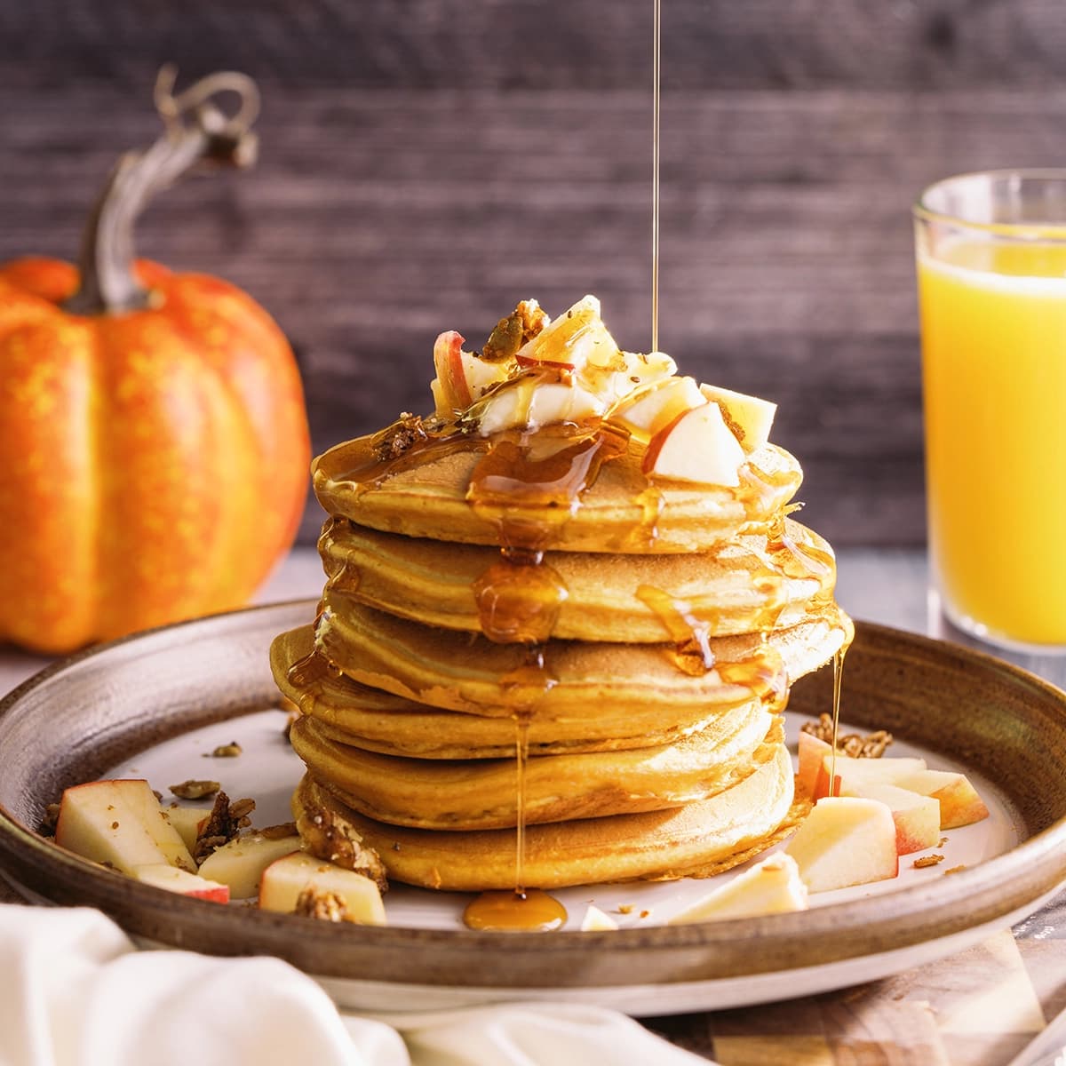 Peanut butter pumpkin spice pancakes with syrup being poured on top