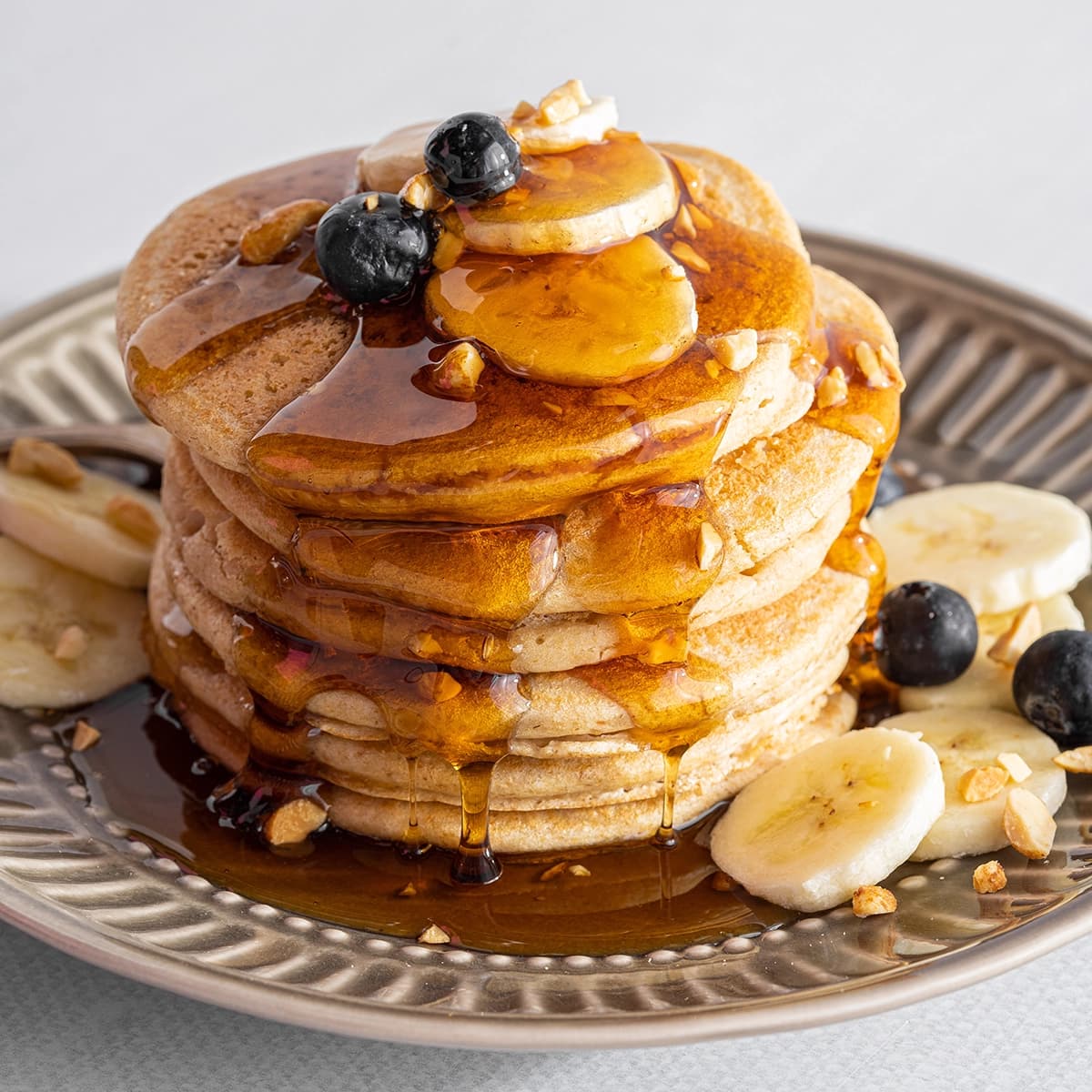 Stack of peanut flour pancakes with syrup on top