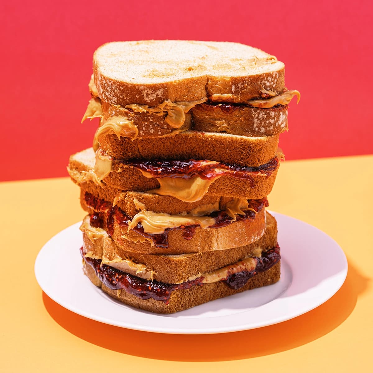 Stack of peanut butter and jelly sandwiches on a plate